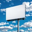 © 1st footage - A blank billboard stands against a vibrant blue sky filled with fluffy clouds, ideal for advertising or promotional displays.