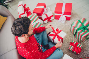 Sticker - High angle view portrait of nice young man unpack present christmas holiday time flat indoors