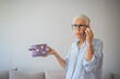 © Dragana Gordic - Senior Woman Talking on Phone While Holding a Pot at Home