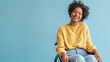 © Anastasiia Shkut - happy young african-american woman sitting in a wheelchair on a light blue background, copyspace banner
