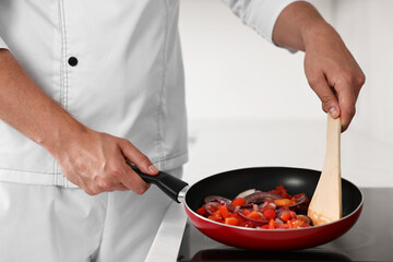 Professional chef cooking delicious food on stove in kitchen, closeup