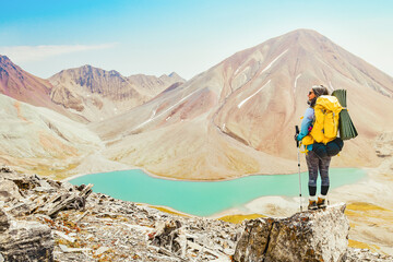 Happy young millennial woman enjoy caucasus mountains view standing over famous turquoise water Kelitsadi lake