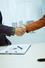 Wall Mural -  A businessman shakes hands with a customer in the sales office after agreeing to sign a contract to buy and sell a condo building. They discuss loans and real estate investment opportunities.