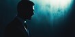 © Kamonwan - Silhouette of a businessman in a suit, captured in low light, exuding mystery and confidence against a dark background.