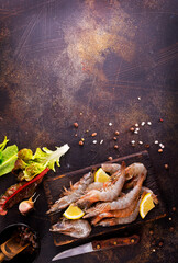 Canvas Print - Raw tiger white shrimp prawn on board with herbs. Dark background. Top view.