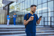 © Dragana Gordic - Smiling Male Nurse Using Smartphone Outdoors at Hospital