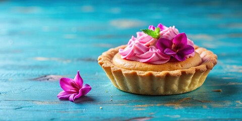 Wall Mural - Bottom view of a small tart with pink pastry cream and purple flowers on a blue table , tart, bottom view, small