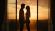 © angel_nt - A couple stands closely together, silhouetted against a breathtaking sunset viewed through expansive windows. The warm glow highlights their romantic connection