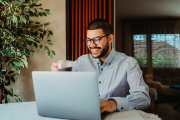 Young caucasian businessman working from home on laptop