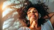 © mutter - Laughing mid-aged african woman relaxing on her bed at home listening to music with her headphones while meditating