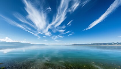 Canvas Print - The beautiful scenery by Qinghai Lake. The water is clear, surrounded by mountains in the distance, the sky is blue, and the clouds are flowing, showing the tranquil natural scenery.