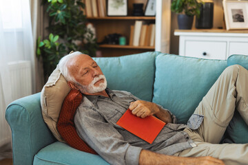 Relax, book and senior man sleeping in the living room of his modern house on a weekend. Calm, peace and elderly male person in retirement taking a nap after reading a story or novel at home.