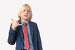 © somemeans - Portrait of a little boy in a blue jacket and red tie make shaka gesture on a white background