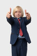 © somemeans - Portrait of a little boy with blond hair in a suit and tie and points at the camera