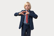 © somemeans - Portrait of blonde businessman in blue suit and red tie making heart with hands isolated over white background