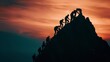 © Shutter2U - Silhouettes of people climbing a mountain at sunset, representing teamwork, success, and reaching goals.