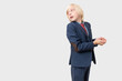 © somemeans - Portrait of a young businessman looking up and thinking over grey background