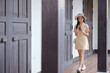 © Treerat - A woman is walking down a hallway with a cell phone in her hand