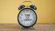 © Lahiru - An alarm clock with 'Time for Lunch' text in middle of it on a yellow background. break for eating, office reminder concept.