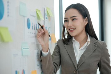 A woman is drawing on a white board with a pen