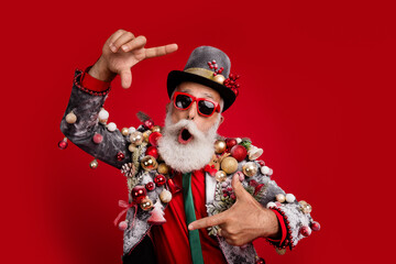 Canvas Print - Photo of handsome good mood santa claus wear suit showing photo gesture enjoying xmas emtpy space isolated red color background