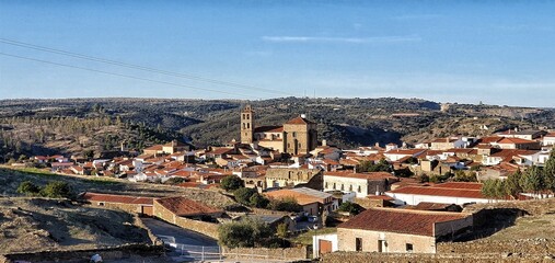 Panoramic view of the village of Arcos de la Frontera, Spain, in broad daylight with blue sky and many old style buildings and almost dry grasslands