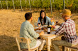 © BGStock72 - Enjoying a sunny afternoon at a vineyard, friends savor delicious food and wine while sharing laughter and stories