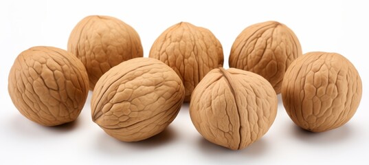 Brown walnuts arranged on a white background showcasing their textured shells and natural appearance