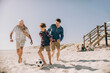 © Marko Geber - Multi-generational family playing soccer on the beach