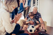 © Marko Geber - Grandparents playing soccer with grandson on patio