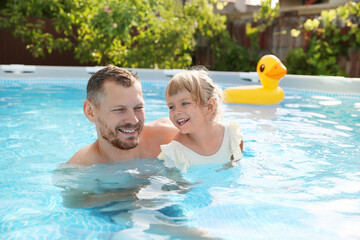 Canvas Print - Happy father having fun with his daughter in swimming pool