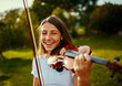 © StarDweller/peopleimages.com - Girl, violin and happy in nature for music, talent and entertainment for event. Musician, string instrument and smile on grass for art, rehearsal and practice for creativity with skill development