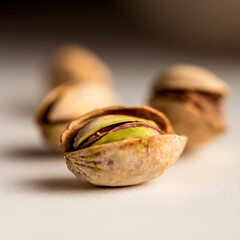 Close-up of a single pistachio with blurred nuts in the background, highlighting healthy snacks and plant-based nutrition, perfect for food photography and snack promotions