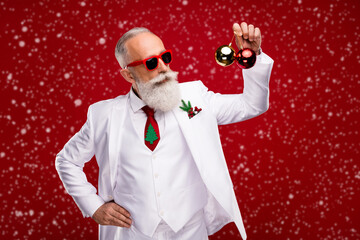 Canvas Print - Photo of nice aged white hair santa man hold balls wear eyewear white jacket isolated on red color background