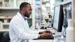 © Bijac - african american scientist in lab coat using computer for pharmaceutical research modern laboratory setting with scientific equipment