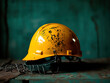 © nitnicha - A worn yellow hard hat resting on a rustic surface, symbolizing safety and construction work in a professional environment.