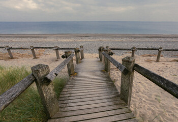 A basic wooden boardwalk allowing easy access to a beach.
