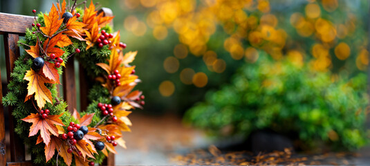 Poster - Autumn Harvest Wreath with Colorful Leaves and Berries on Rustic Wooden Chair .Home decor for fall holidays Halloween or Thanksgiving