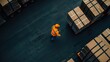 © K-MookPan - Aerial view of a warehouse worker in a safety vest managing packages on a loading dock, showcasing logistics and organization.
