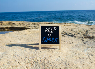 Keep it Simple symbol. Concept words Keep it Simple on chalk blackboard. Beautiful sea background. Business and Keep it Simple concept. Copy space.