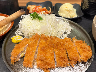 Deliciously crispy katsu dish plated with fresh cabbage and sides, showcasing the art of Japanese cuisine.