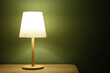 © Pixel-Shot - Glowing lamp on wooden table in dark room