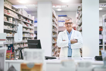 Canvas Print - Arms crossed, mature and portrait of man in pharmacy for healthcare, prescription or medical. Dispensary, medicine and wellness with happy pharmacist in drugstore for professional consultation