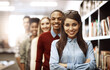 © peopleimages.com - Portrait, happy woman and students in row at library in university for learning or education. Face, smile and people together at college for diversity, teamwork or confident leader with arms crossed