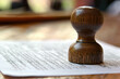 © Kitta - A close up of wooden government office stamp on document, symbolizing authority