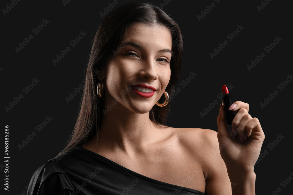 Beautiful young woman with red lipstick on black background