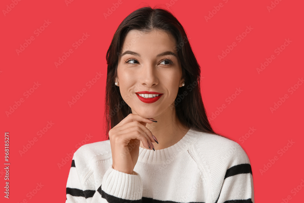 Beautiful young woman with bright lipstick on red background