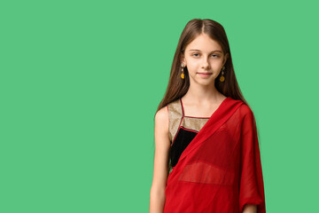 Wall Mural - Cute little Indian girl in sari on green background. Divaly celebration