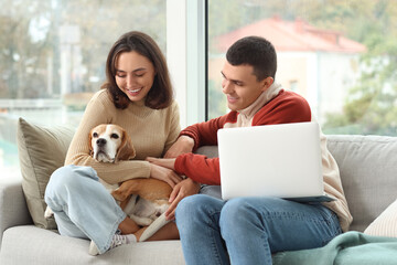 Sticker - Young couple with cute Beagle dog and laptop at home