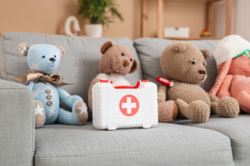 Poster - Toy first aid kit and teddy bears on sofa at home